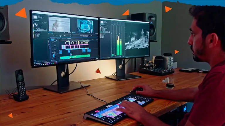 An editor working across two monitors in an edit suite